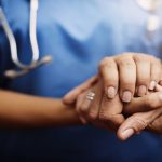 Nurse and patient holding hands
